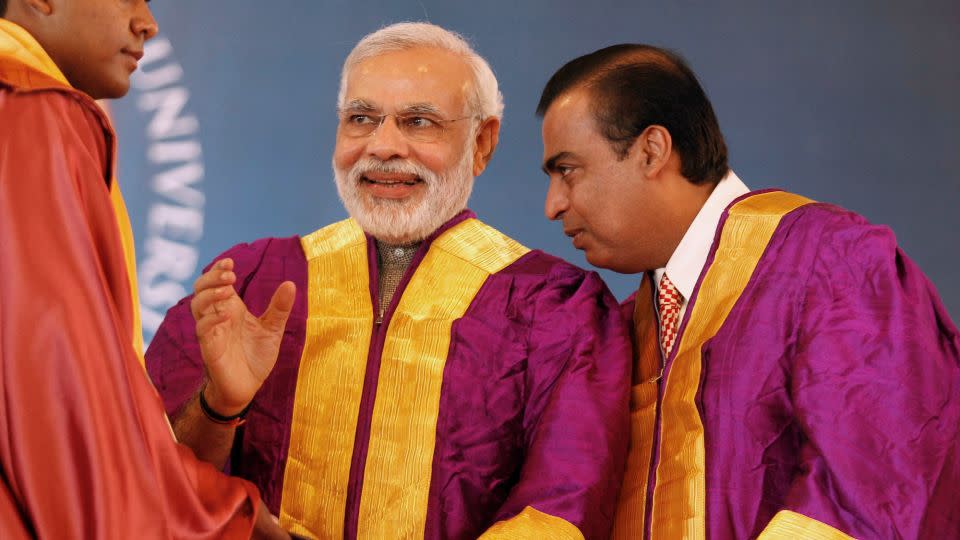 Mukesh Ambani (right) is pictured with Narendra Modi (center) at a university graduation ceremony in the western Indian state of Gujarat on October 19, 2013. - Amit Dave/Reuters/File