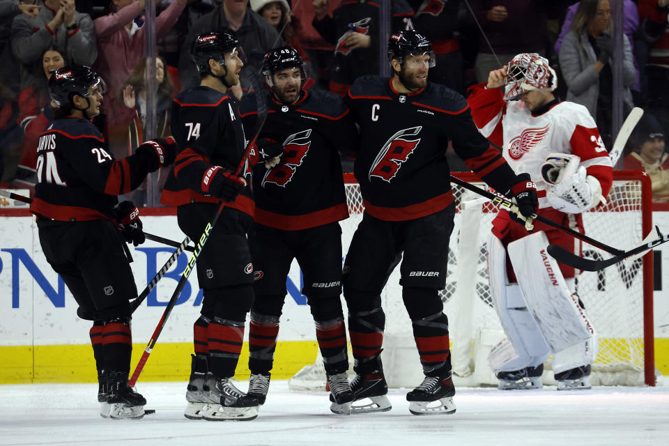 Carolina Hurricanes celebrate after a goal by Jordan Martinook, center, during the first period of an NHL hockey game against the Detroit Red Wings in Raleigh, N.C., Friday, Jan. 19, 2024. (AP Photo/Karl B DeBlaker)