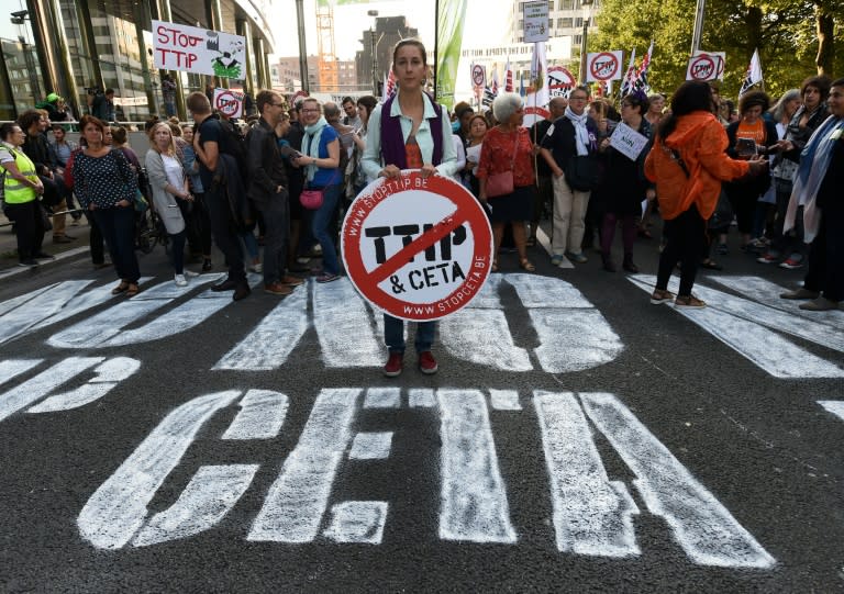 A woman holds an anti-TTIP and CETA placard during a demonstration outside the EU headquarters in Brussels, on September 20, 2016 to protest against huge transatlantic trade deals linking Europe with Canada and the US