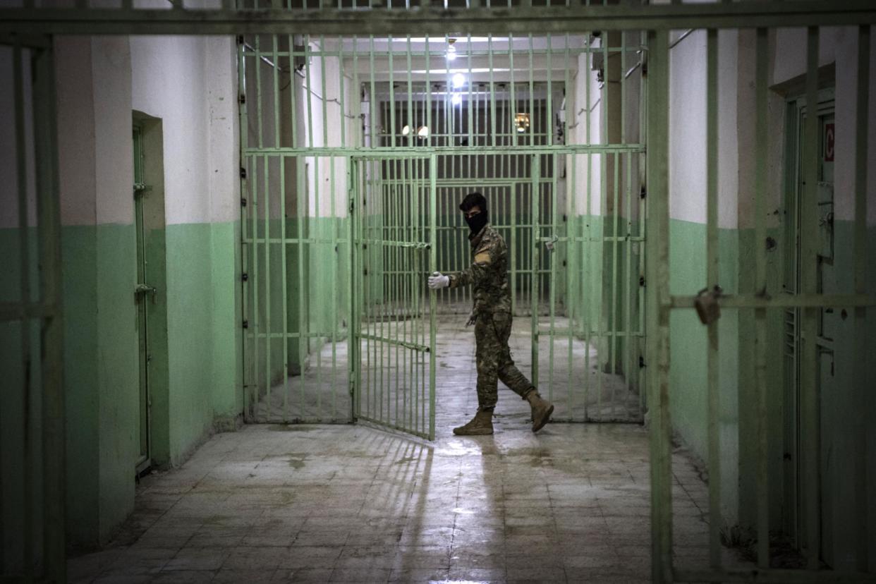 A member of the Syrian Democratic Forces (SDF) stands guard in a prison where men suspected to be affiliated with the Islamic State (IS) group are jailed in northeast Syria in the city of Hasakeh: Getty