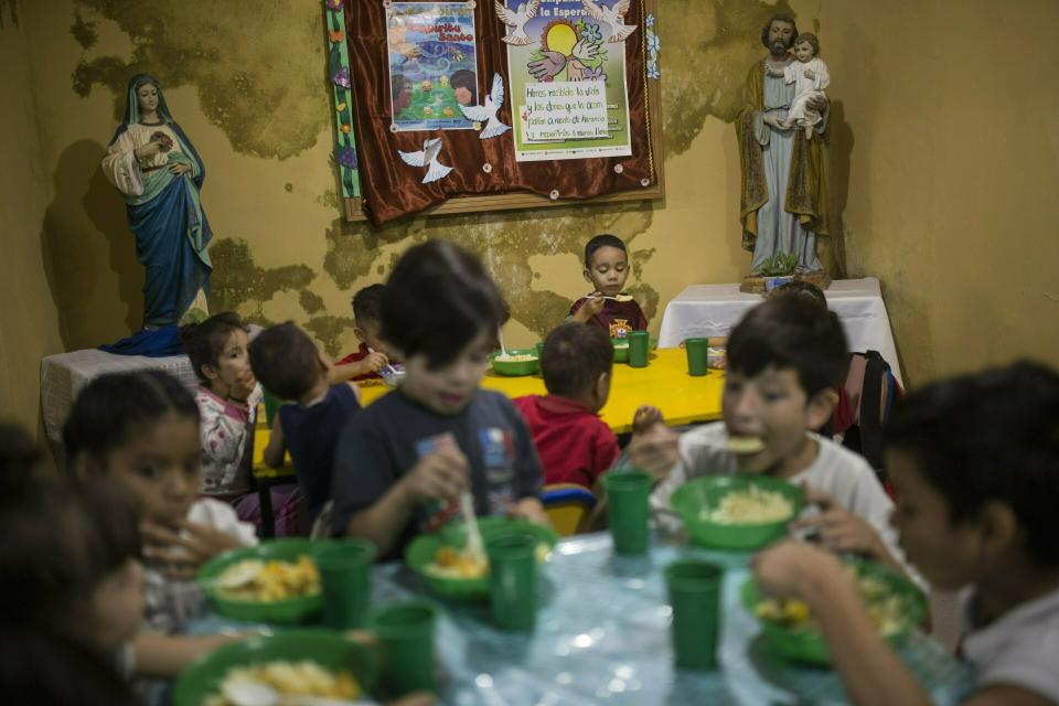 FILE - In this Feb. 11, 2019 file photo, children have lunch in the San Antonio de Padua soup kitchen in Petare slum of Caracas, Venezuela. In the throes of an economic downturn worse than the U.S. Great Depression, Venezuela will need the knowledge, contacts and financial resources many exiles took with them. One prominent economist predicts Venezuela will need a $60 billion cash infusion just to begin a turnaround. (AP Photo/Rodrigo Abd, File)