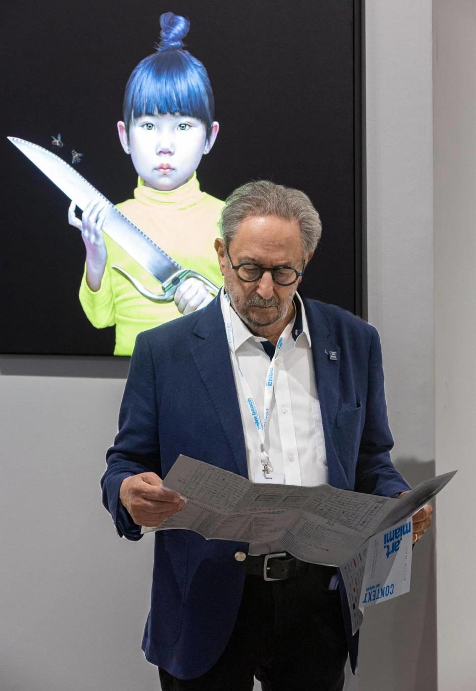 Raymond S. Elman looks at show floor map next to Salustiano’s “Tenderness Land” during a VIP preview at Art Miami 2023 on Tuesday, Dec. 5, 2023, in downtown Miami, Fla. MATIAS J. OCNER/mocner@miamiherald.com