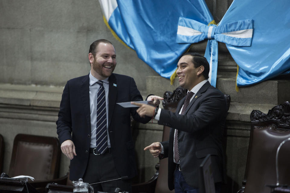 Guatemalan Congress President, Alvaro Arzu Escobar, left, has a laugh with congressman Juan Manuel Giordano during a session of Congress in Guatemala City, Wednesday, Dec. 11, 2019. Guatemala’s congress is leading their own investigative commission against the U.N.-sponsored anti-graft commission that over the course of 12 years helped bring to justice hundreds of politicians, businesspeople, judges and others accused of corruption. (AP Photo/Oliver de Ros)