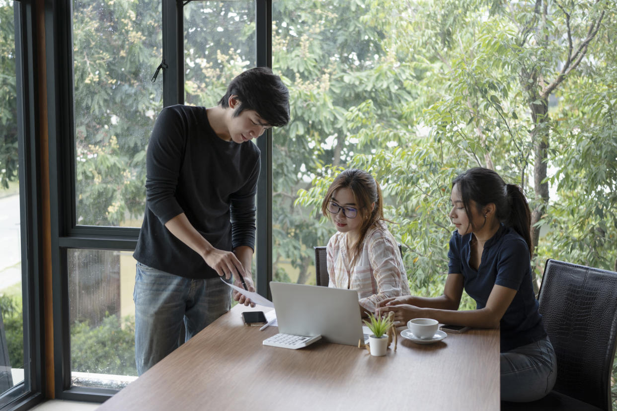 Group of young business people working on new project together in modern office.