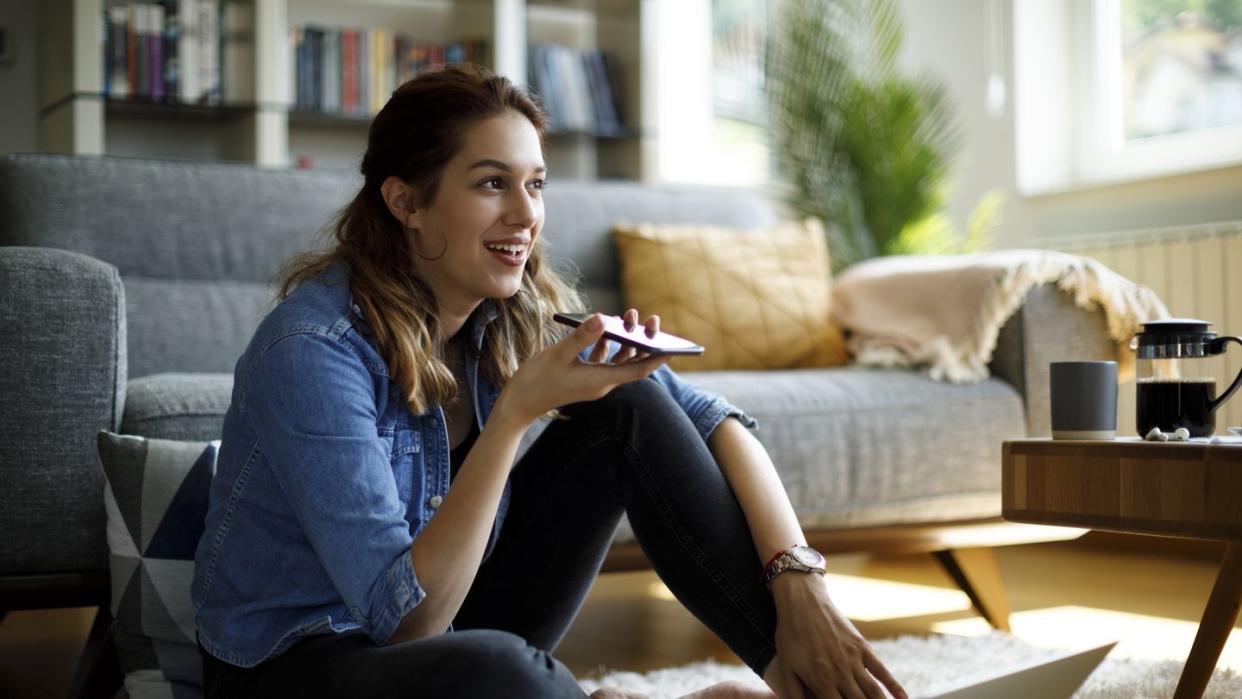 young woman using speaker phone on smartphone