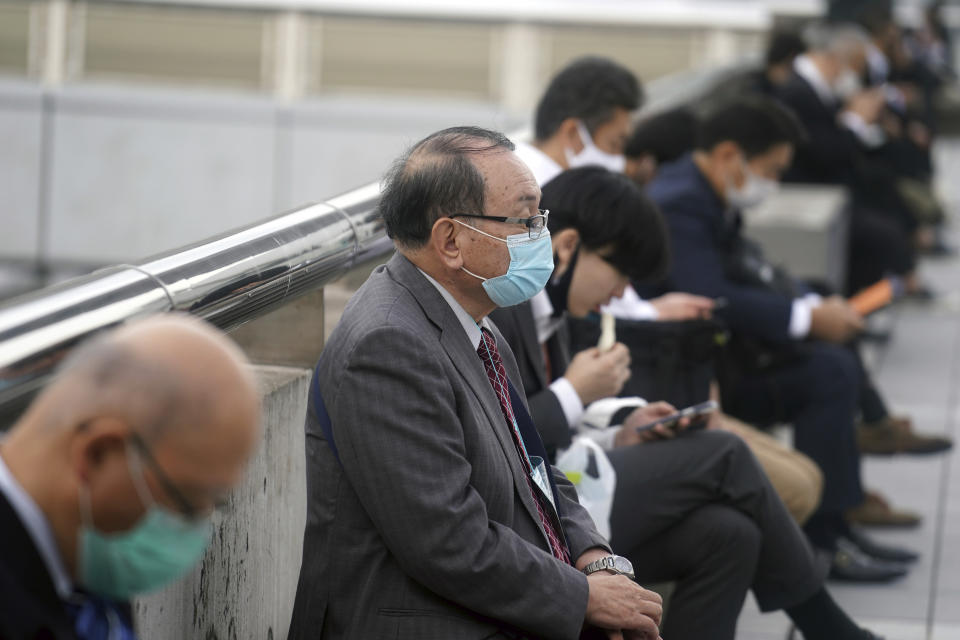 People wearing protective masks to help curb the spread of the coronavirus rest in Chiba, near Tokyo, Wednesday, Oct. 28, 2020. (AP Photo/Eugene Hoshiko)