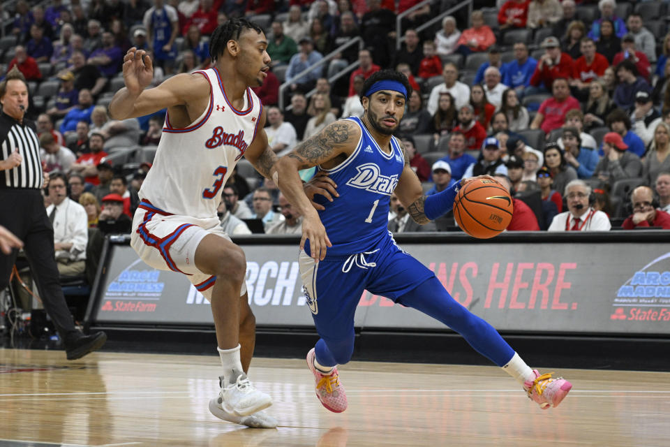 Drake guard Roman Penn (1) drives to the net as Bradley guard Zek Montgomery (3) defends during the first half of the championship game in the MVC basketball tournament, Sunday, March 5, 2023, in St. Louis. (AP Photo/Joe Puetz)