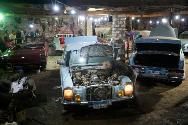 Mechanics work on a 1976 Mercedes at a private car collector’s lot in El Saff city in the Giza, just outside Cairo, Egypt