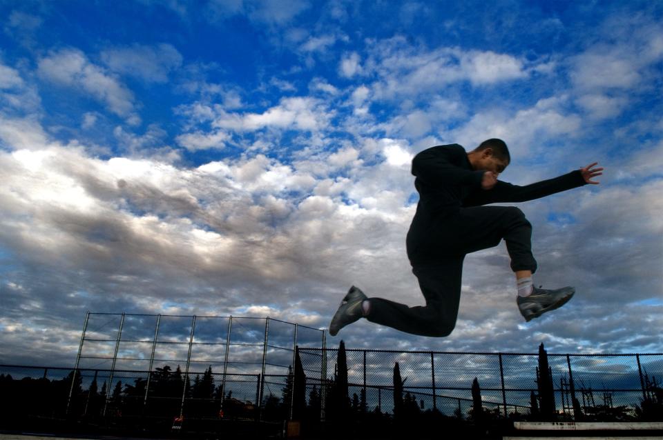 Delta College track team member Aamir Khan is greeted by cloudy skies as he practices his triple jump at Delta's DiRicco Field in Stockton on Dec. 10, 2008. A fast shutter speed of 1/500th of a second was used to stop the motion.