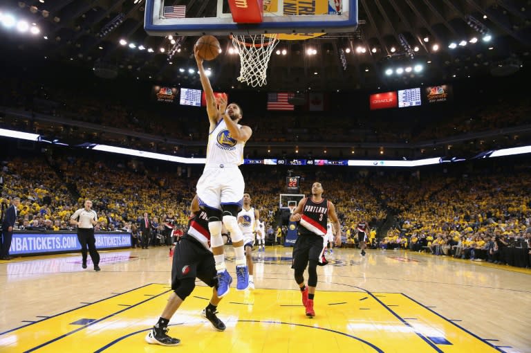 Stephen Curry of the Golden State Warriors goes up for a shot against Evan Turner of the Portland Trail Blazers in Game Two of the Western Conference Quarterfinals