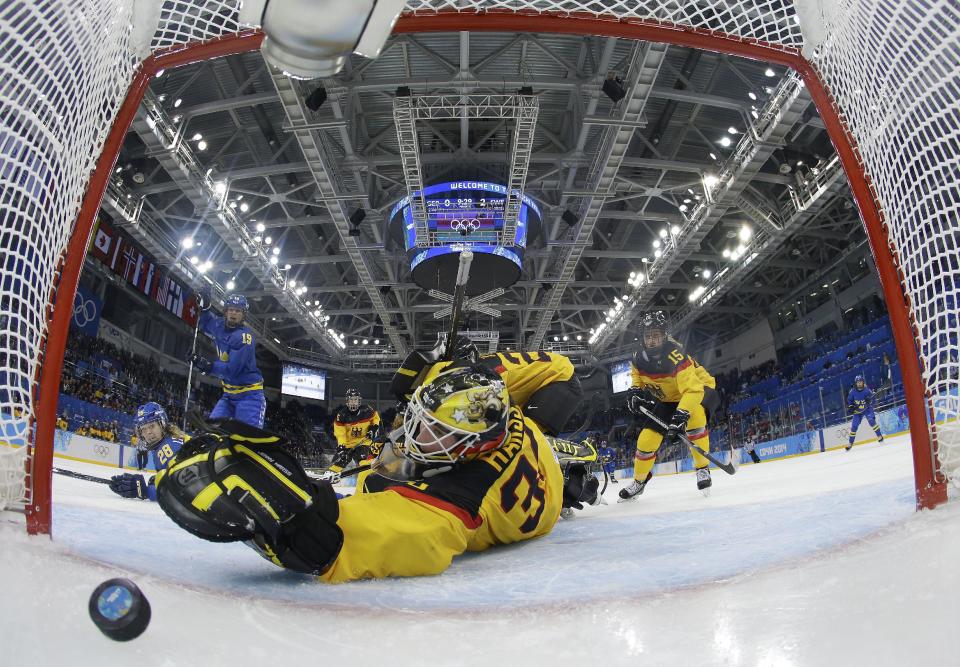 Goalkeeper Jennifer Harss of Germany reaches for the puck as Johanna Olofsson's of Sweden shot get by her for a goal during the third period of women's ice game at Shayba Arean during the 2014 Winter Olympics, Tuesday, Feb. 11, 2014, in Sochi, Russia. (AP Photo/Mark Blinch, Pool)