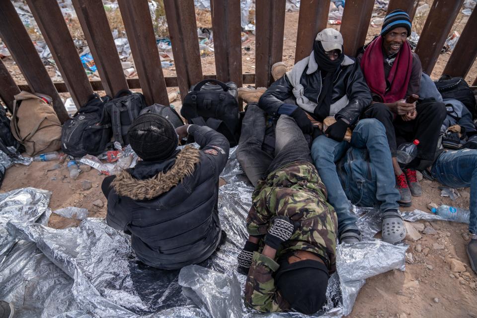 Migrants and asylum seekers from Mauritania, Africa, wait to be picked up and processed by U.S. Border Patrol agents in Organ Pipe Cactus National Monument along the U.S.-Mexico border about a mile west of Lukeville, Ariz., on Dec. 4, 2023. The Lukeville Port of Entry was closed indefinitely by officials Dec. 4.