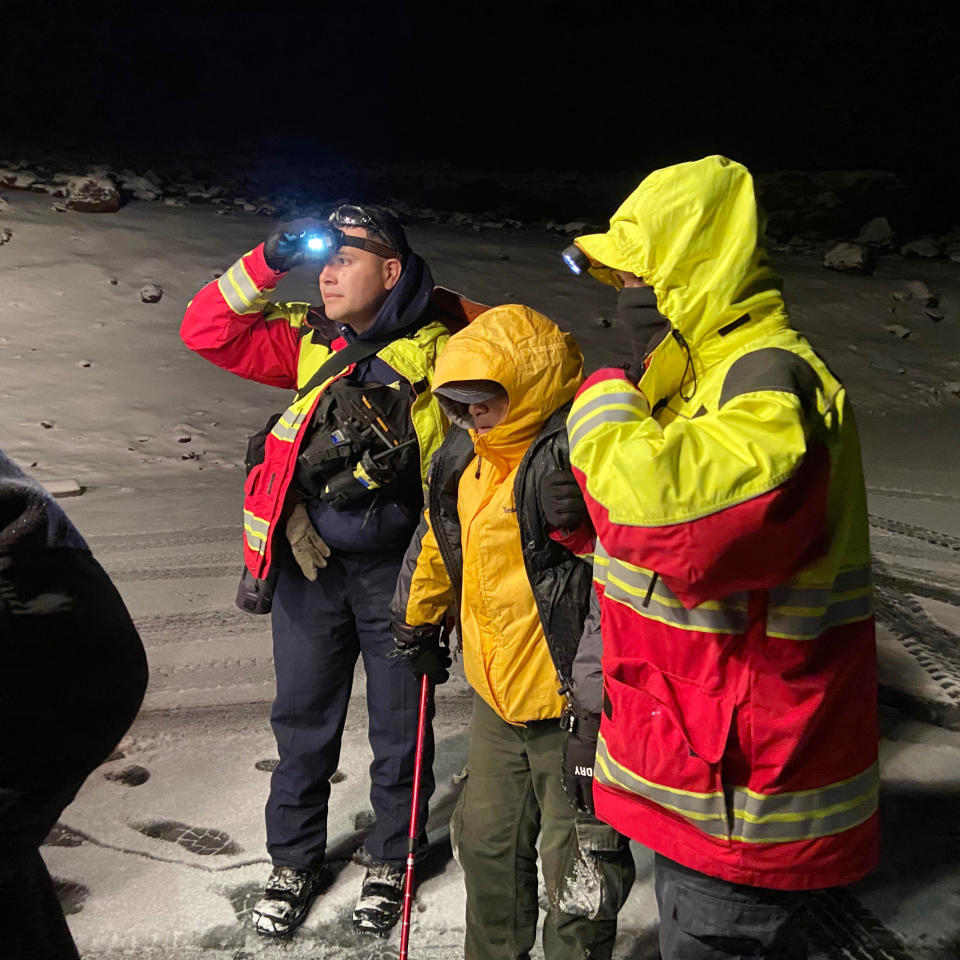 In this photo provided by Center for Maunakea Stewardship, The University of Hawaiʻi Maunakea Rangers rescue a lost hiker found on the Humuʻula Trail Tuesday, Dec. 21, 2021, on the island of Hawaii. Rangers, fire and rescue personnel from the U.S. Army Pohakuloa Training Center, trekked through heavy snow and sleet to find the hiker lost in one of the most dangerous places in Hawaii, after he set off for a hike on Mauna Kea Tuesday morning. The hiker was found Tuesday night in a small cave in “thick white-out conditions" at 13,000 feet above sea level, the center's news release said. (Center for Maunakea Stewardship via AP)