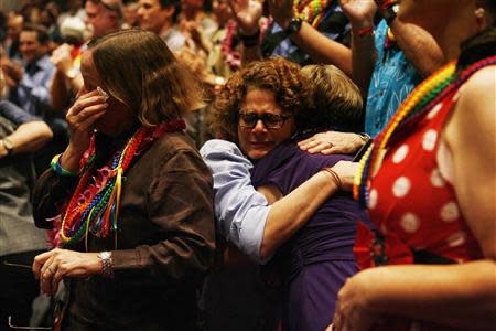 Eileen McKee (C) hugs Carolyn Golujuch after Hawaii Governor Neil Abercrombie signed Senate Bill 1, allowing same sex marriage to be legal in the state, in Honolulu, Hawaii November 13, 2013. REUTERS/Hugh Gentry