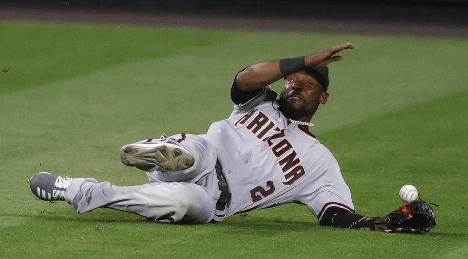 Arizona Diamondbacks center fielder Starling Marte tries to catch a ball hit by Colorado Rockies' Raimel Tapia that fell in for a two-run double during the eighth inning of a baseball game Tuesday, Aug. 11, 2020, in Denver. The Rockies won 8-7. (AP Photo/David Zalubowski)