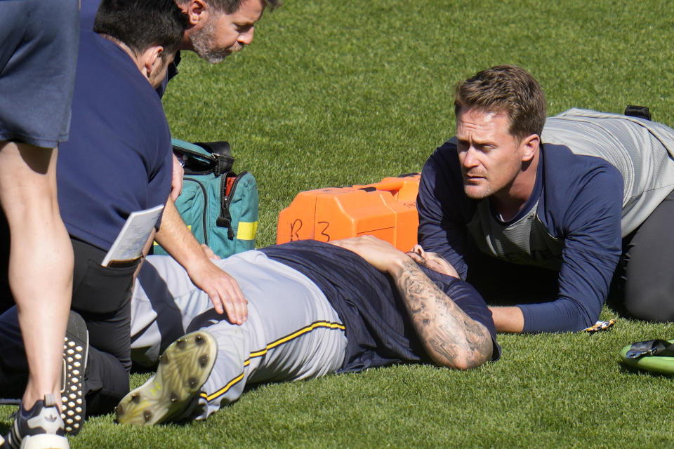 Milwaukee Brewers pitcher Jakob Junis is tended to as he lies in the outfield of PNC Park after being hit by a ball during batting practice before a baseball game against the Pittsburgh Pirates in Pittsburgh, Monday, April 22, 2024. Junis was taken from the field in an ambulance. (AP Photo/Gene J. Puskar)