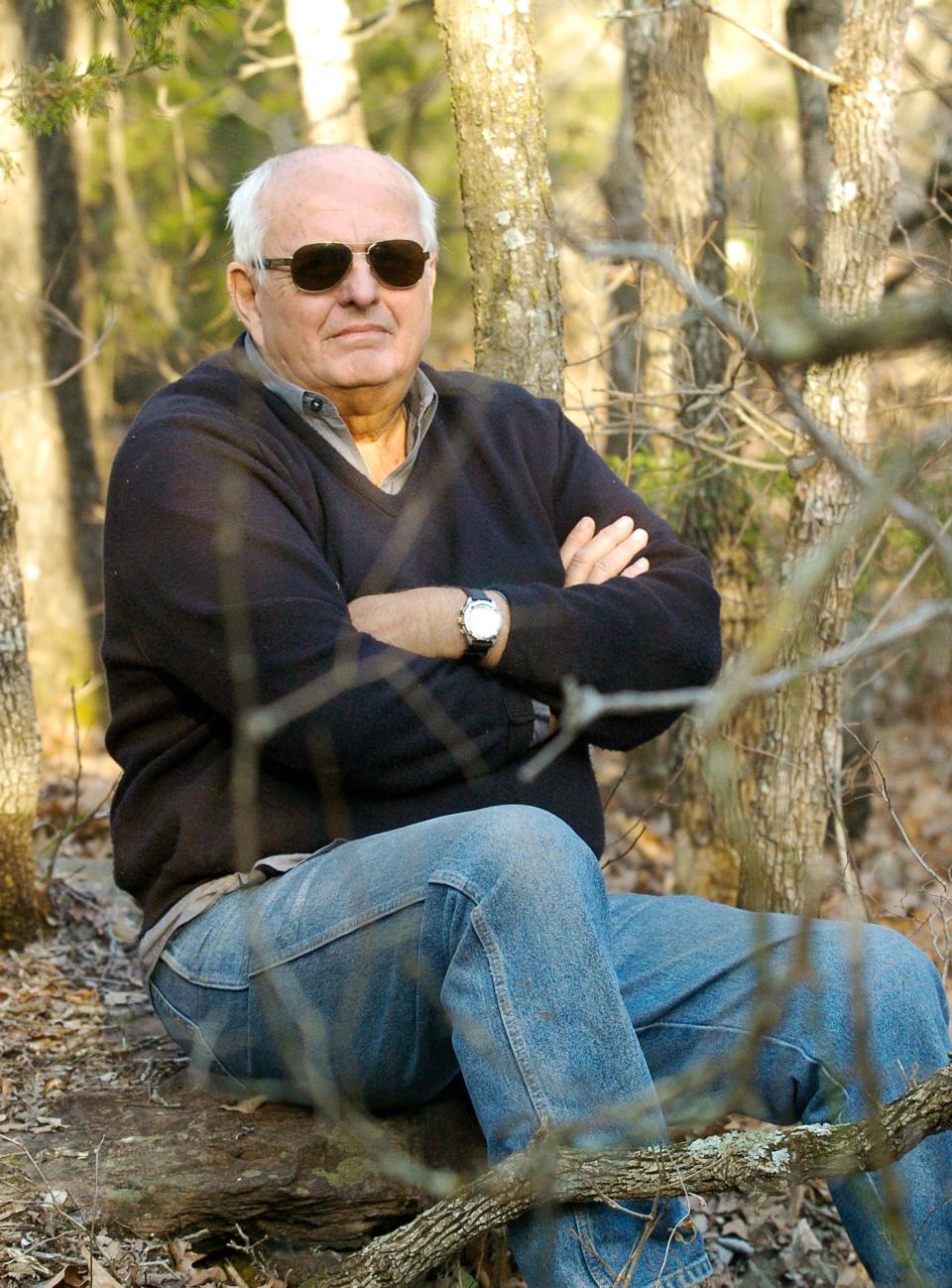 Producer Gray Frederickson sits on a large rock to watch filming of the movie "The Hunt" in 2005 in a wooded area of Logan County.