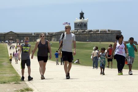 Tourists walk in front of Fort San Felipe del Morro in San Juan, Puerto Rico, July 18, 2015. REUTERS/Alvin Baez