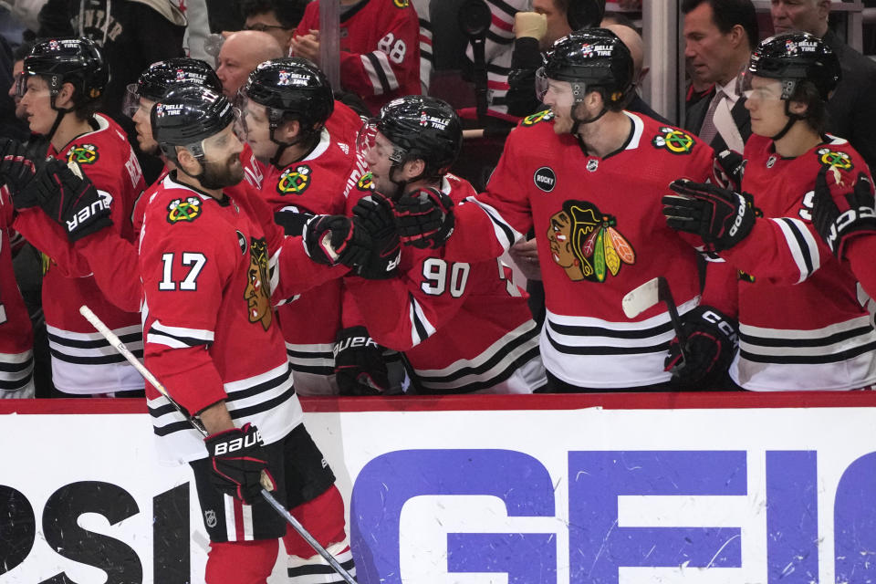 Chicago Blackhawks left wing Nick Foligno (17) celebrates with teammates after scoring his goal during the first period of an NHL hockey game against the Vancouver Canucks in Chicago, Sunday, Dec. 17, 2023. (AP Photo/Nam Y. Huh)