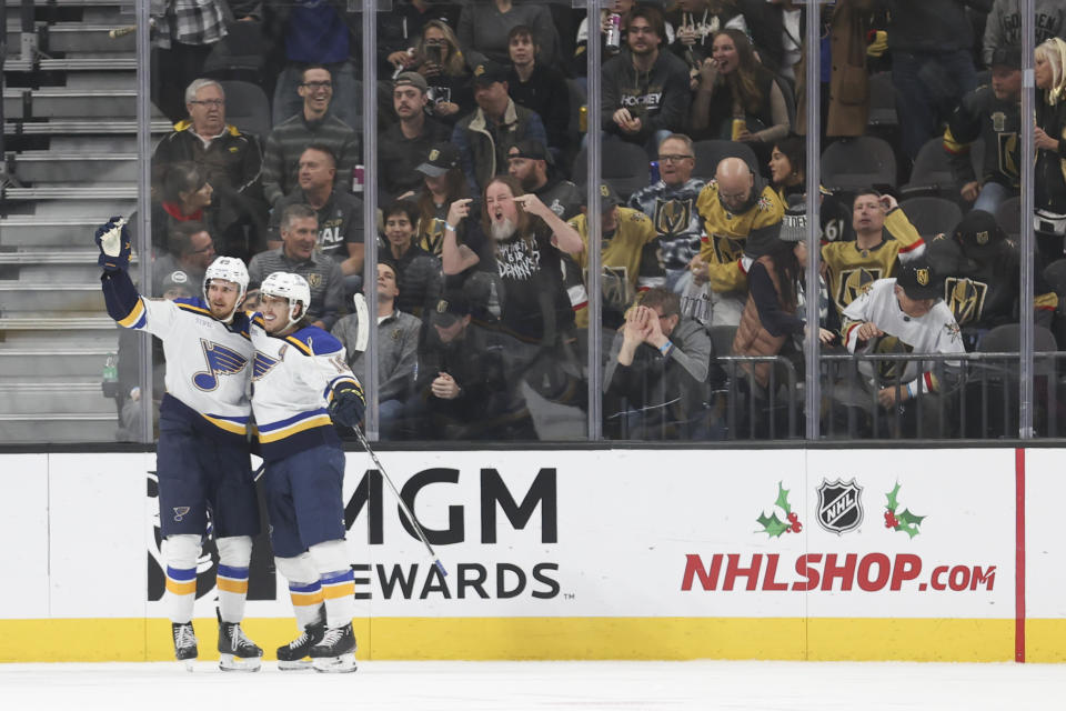St. Louis Blues left wing Pavel Buchnevich (89) and center Robert Thomas (18) celebrate after Buchnevich's game-winning goal in overtime of an NHL hockey game Monday, Dec. 4, 2023, in Las Vegas. St. Louis won 2-1. (AP Photo/Ian Maule)