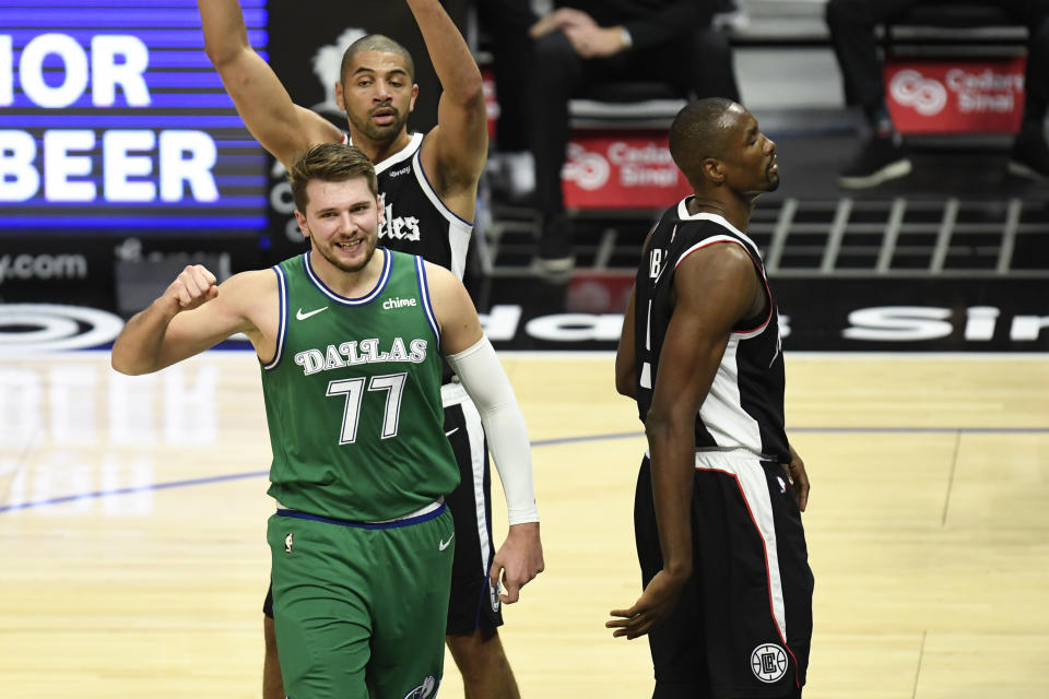 Dallas Mavericks guard Luka Doncic, bottom left, reacts after drawing a foul during the first half of an NBA basketball game against the Dallas Mavericks in Los Angeles, Sunday, Dec. 27, 2020. (AP Photo/Kyusung Gong)