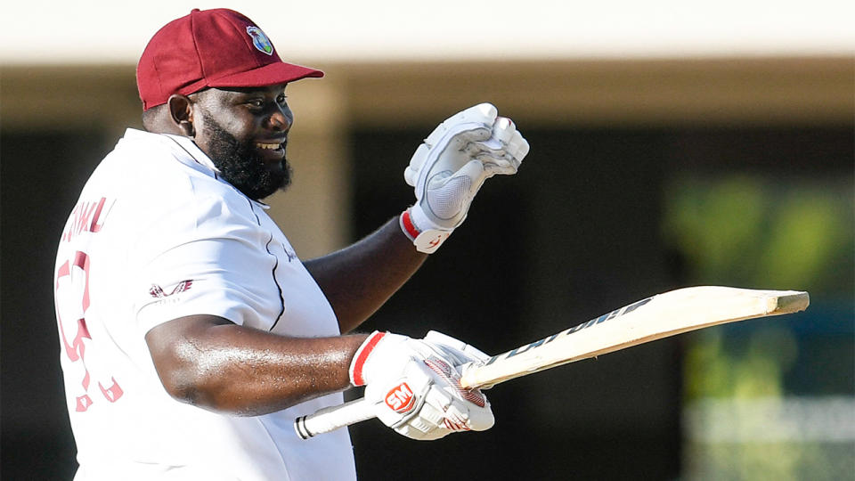 Rahkeem Cornwall (pictured) raising his bat and smiling after his maiden Test 50.