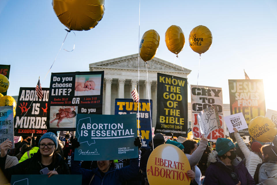 Anti-abortion protesters and abortion rights advocates demonstrate in front of the Supreme Court building, with signs reading: Jesus saves from Hell and balloons reading: Bans off our bodies.