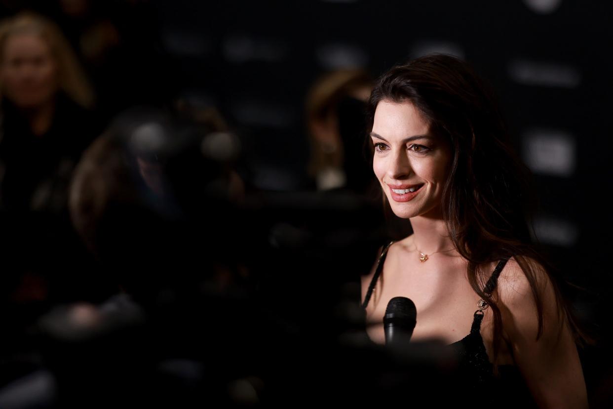 Anne Hathaway is interviewed with a microphone at the premiere of "Eileen" at the Sundance Film Festival.