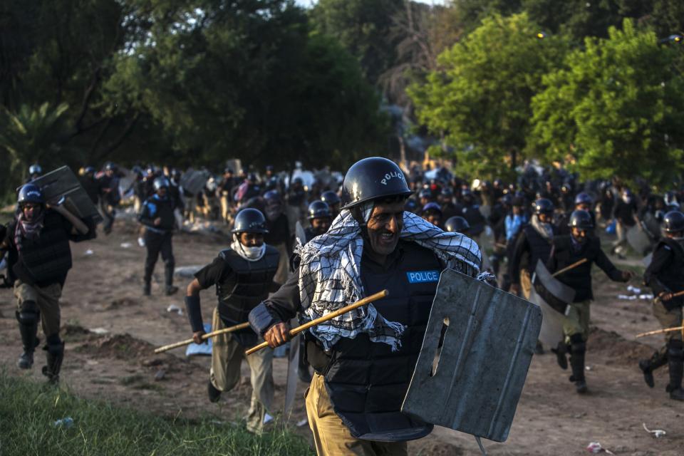 Riot police run away from Supporters of Tahir ul-Qadri, Sufi cleric and leader of political party Pakistan Awami Tehreek (PAT), during the Revolution March in Islamabad August 31, 2014. (REUTERS/Akhtar Soomro)