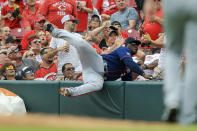 Minnesota Twins' Miguel Sano (22) falls into the safety net as he attempts to catch a foul ball hit by Cincinnati Reds' Eugenio Suarez (7) in the second inning of a baseball game in Cincinnati, Wednesday, Aug. 4, 2021. (AP Photo/Aaron Doster)