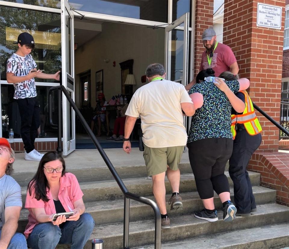 A woman suffering from Saturday's heat at the Trump rally in Pickens is guided into a temporary shelter inside Pickens First Baptist Church, only two blocks from where Trump spoke.