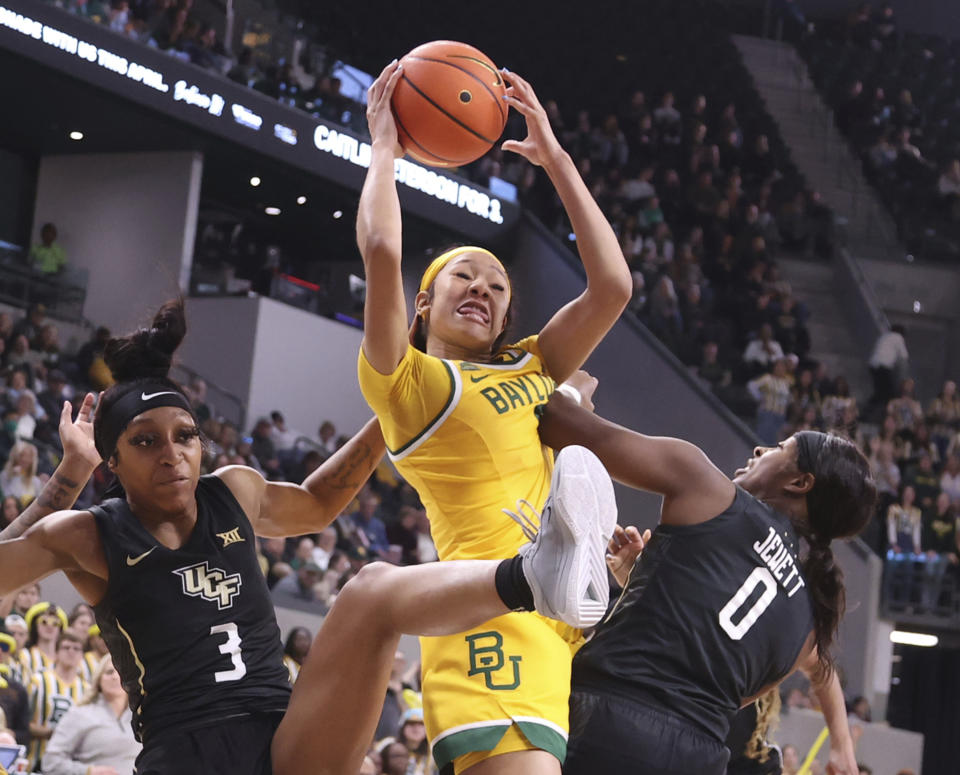 Baylor guard Darianna Littlepage-Buggs, center, pulls down a rebound over Central Florida guards Kaitlin Peterson, left, and Laila Jewett, right, in the second half of an NCAA college basketball game, Saturday, Jan. 20, 2024, in Waco, Texas. (Rod Aydlotte/Waco Tribune-Herald via AP)