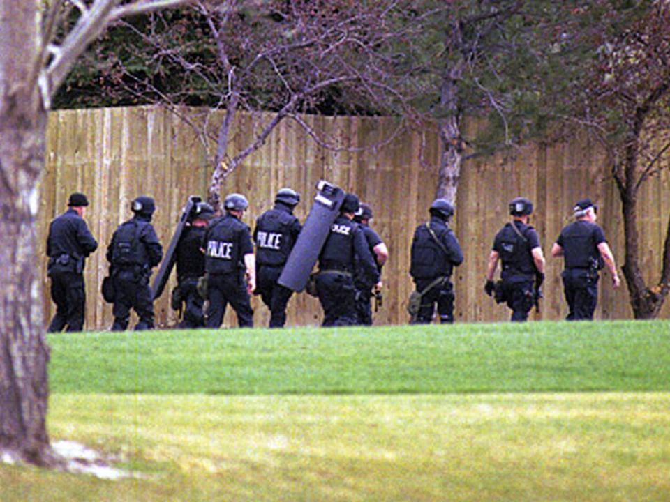 Swat policemen arrive at the high school in Littleton where a shootout claimed 15 lives.