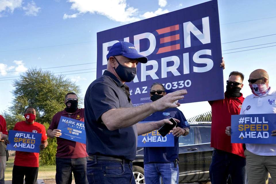 Mark Kelly, Democratic candidate for the U.S. Senate, greets supporters at a polling station, Tuesday, Nov. 3, 2020, in Phoenix. Kelly is seeking to unseat incumbent Martha McSally. (AP Photo/Matt York)