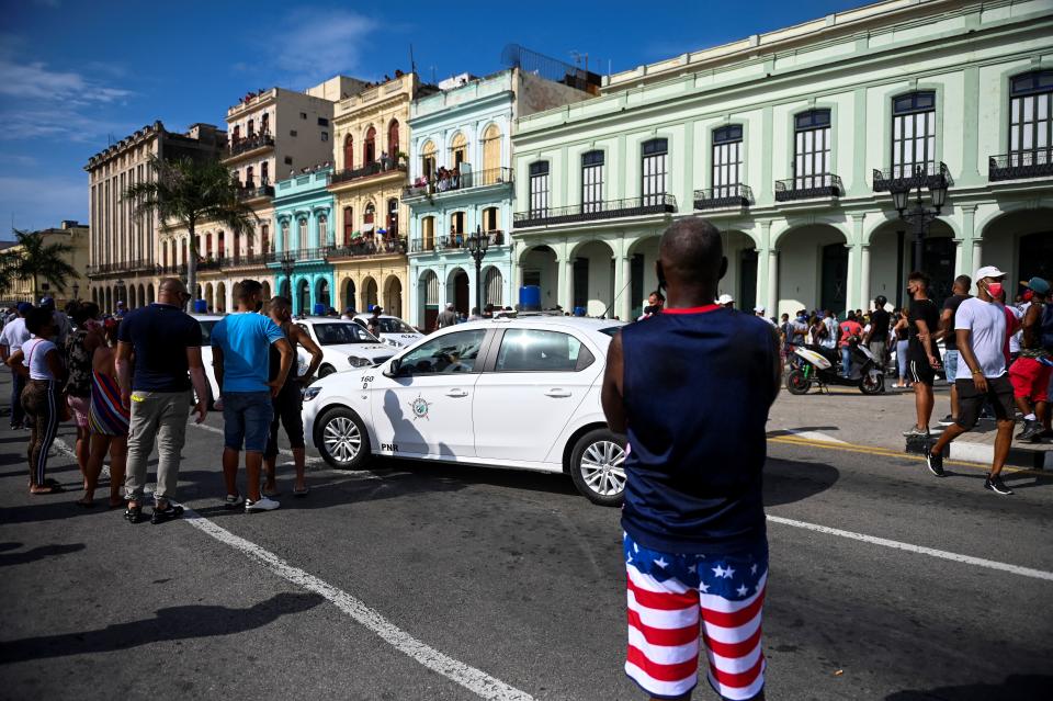Cubans march in front of Havana's Capitol during a demonstration against the government of Cuban President Miguel Diaz-Canel in Havana, on July 11, 2021. - Thousands of Cubans took part in rare protests Sunday against the communist government, marching through a town chanting 