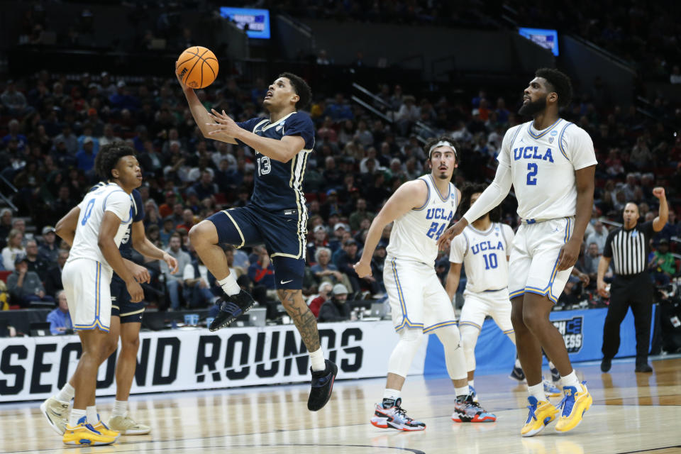 Akron guard Xavier Castaneda (13) leaps to put up a shot as UCLA forward Cody Riley (2) and UCLA guard Jaime Jaquez Jr. (24) look on during the second half of a first-round NCAA college basketball tournament game, Thursday, March 17, 2022, in Portland, Ore. (AP Photo/Craig Mitchelldyer)