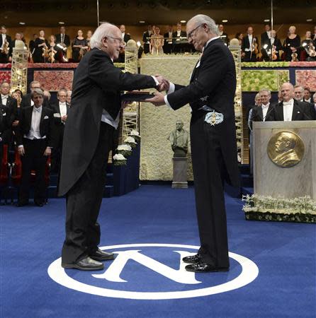 Peter Higgs (L) of Britain receives his Nobel Prize in Physics from Sweden's King Carl Gustaf during the 2013 Nobel Prize award ceremony in Stockholm December 10, 2013. REUTERS/Claudio Bresciani