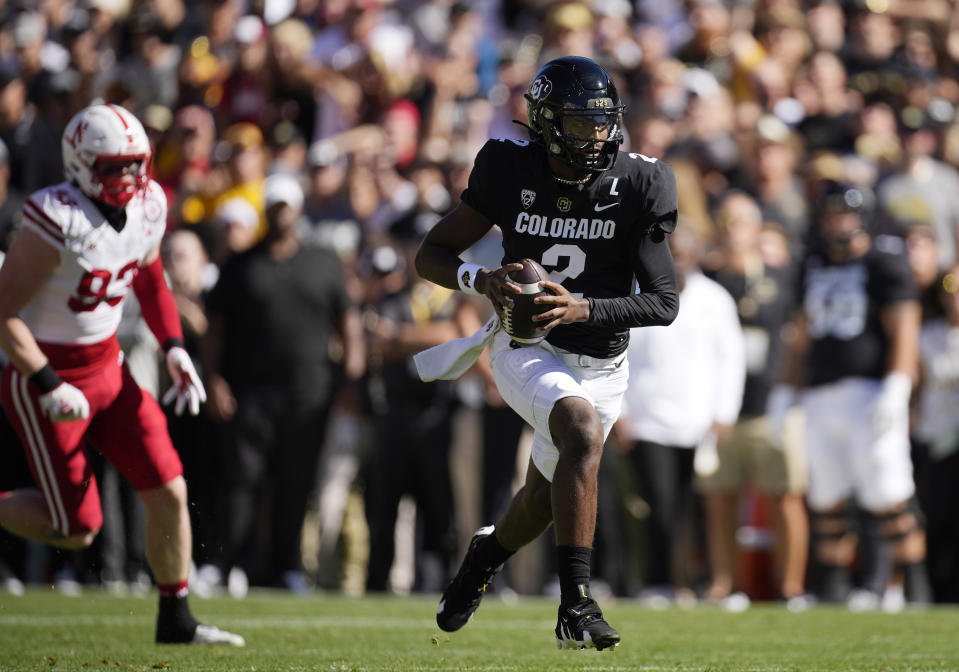 Colorado quarterback Shedeur Sanders, right, runs for a short gain as Nebraska defensive lineman Kai Wallin pursues in the first half of an NCAA college football game Saturday, Sept. 9, 2023, in Boulder, Colo. (AP Photo/David Zalubowski)