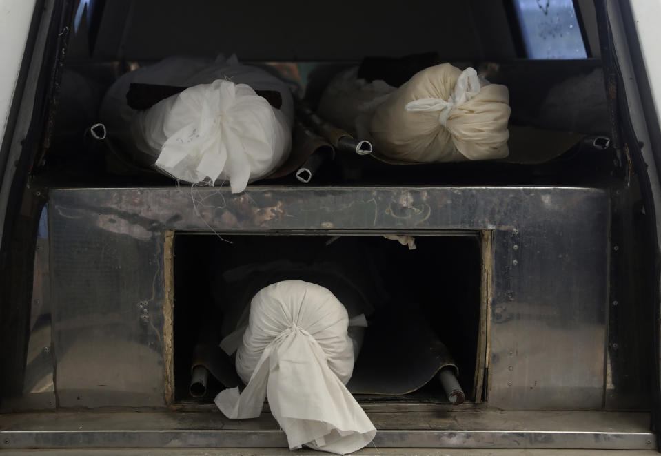 Bodies of a Covid-19 victims are shrouded and prepared to transfer for burial at Behesht-e-Masoumeh cemetery just outside the city of Qom, some 80 miles (125 kilometers) south of the capital Tehran, Iran, Wednesday, Sept. 15, 2021. (AP Photo/Vahid Salemi)