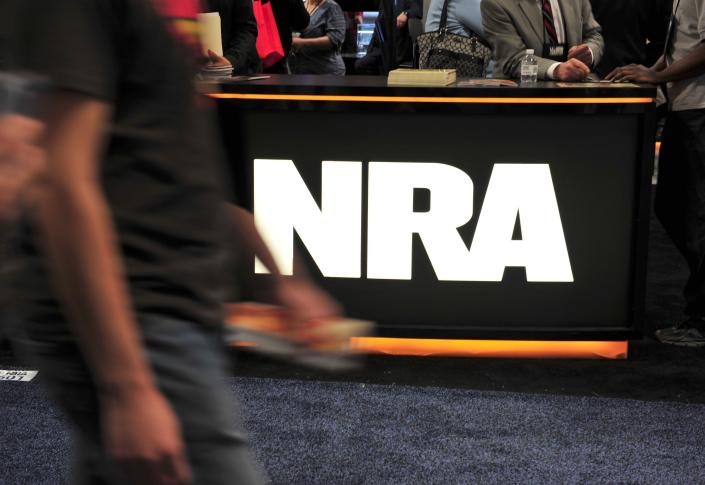 A convention goer passes the NRA desk at the 2015 NRA Annual Convention.