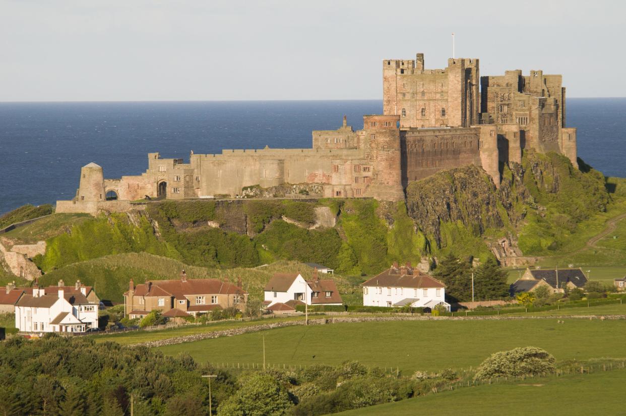 Seaside  View fields and village towards castle, Bamburgh Castle, Northumberland, England, United Kingdom