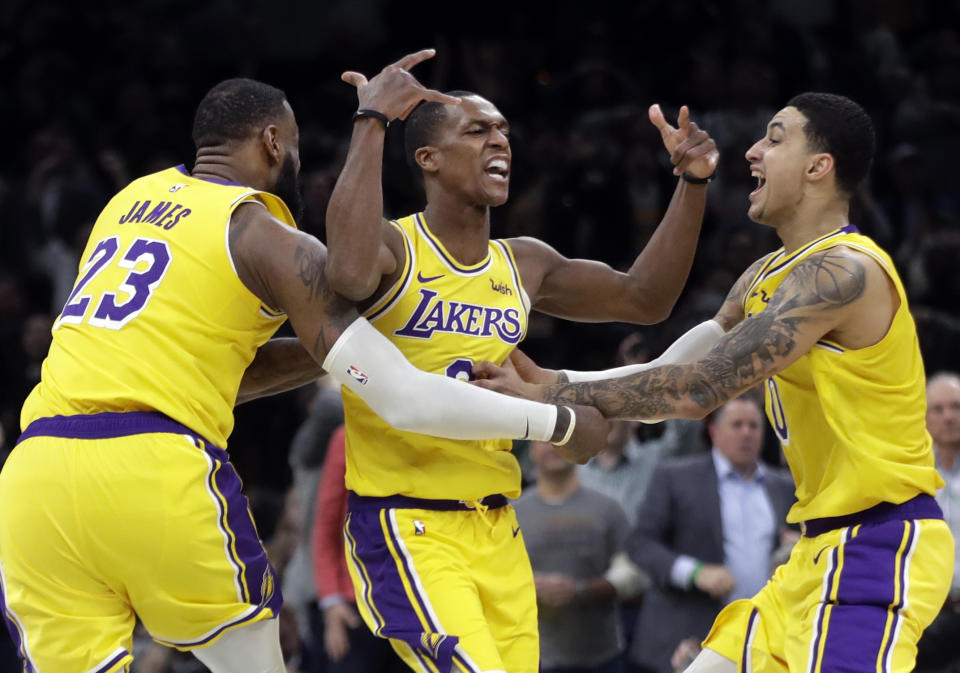 Lakers guard Rajon Rondo (center) celebrates his game-winning shot with teammates LeBron James and Kyle Kuzma. (AP)