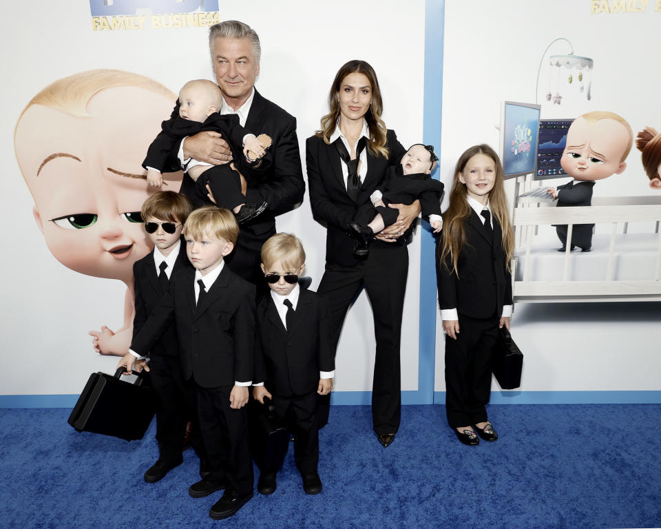 Alec and Hilaria with six kids, all wearing black suit and tie