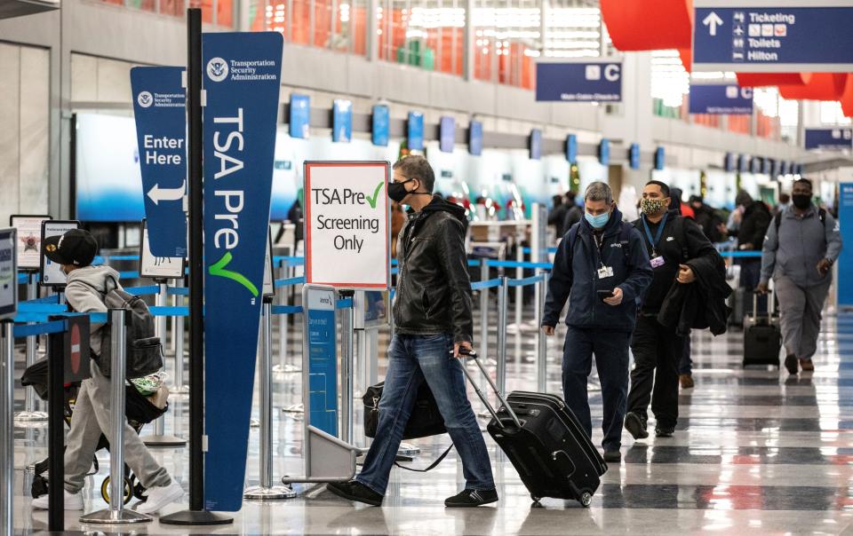 Travelers wearing face masks line up for security checks at O'Hare International Airport in Chicago, the United States, on Nov. 25, 2020. (Joel Lerner/Xinhua via Getty Images) 
