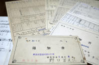 Report cards of Fumie Sato's first to sixth grades from the elementary school in Manchuria, China, are seen Friday, Aug. 7, 2020, at her home in Yokohama, Japan. Hours after Sato heard Emperor Hirohito's Aug. 15 radio speech declaring Japan's defeat at her school ground in Manchuria, China, she had to be prepared for honorable suicide with her family, though her father decided his family must live. Two years later she almost became an orphan when her little sister died of illness after their mother and little brother took an earlier boat back to Japan. (AP Photo/Kiichiro Sato)
