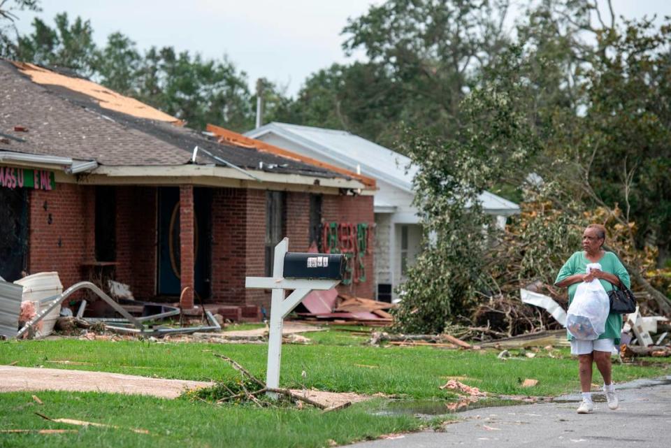 A woman carries personal belongings in a trash bag in Moss Point on Tuesday, June 20, 2023, after a tornado tore through the town on Monday.