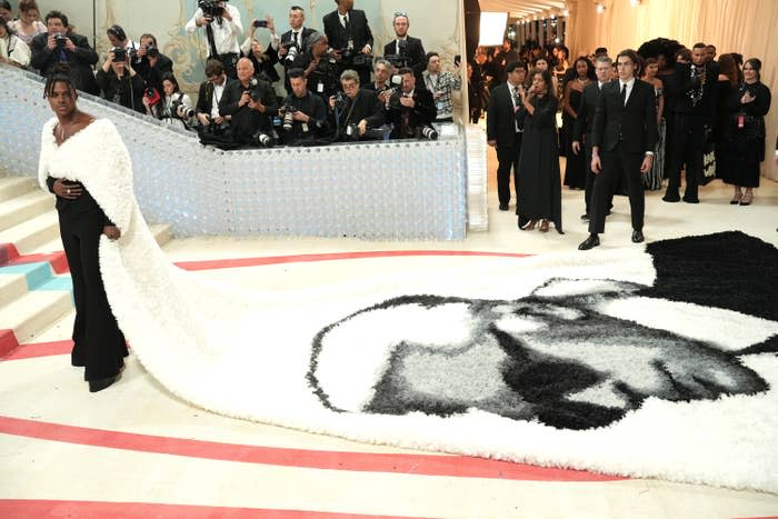 Jeremy Pope in a long cape with an illustration of Karl Lagerfeld's face