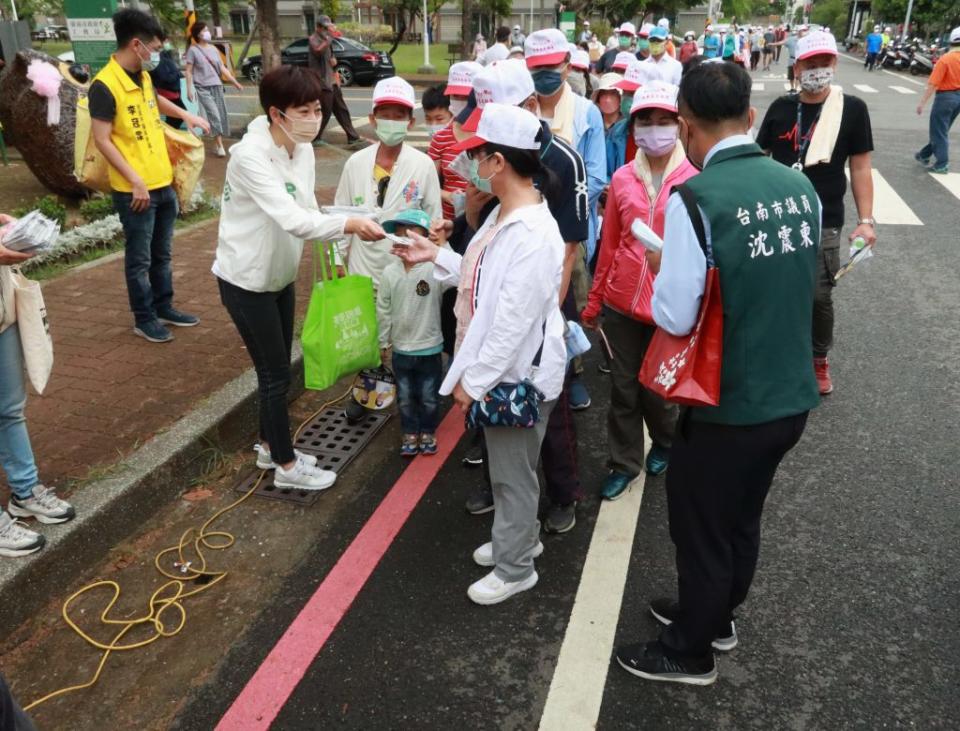 幾位初選民調過關的市議員在現場分贈口罩向民眾致謝。（記者陳俊文攝）