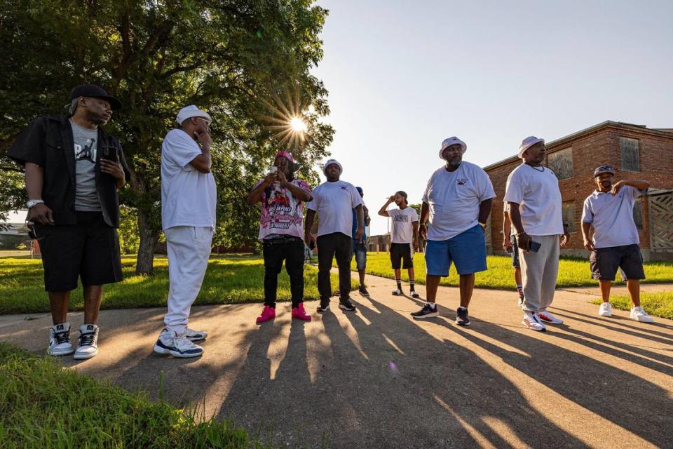 Former Butler Place residents catch up on memories next to ‘Pork Chop Hill.’ They used to slide down the grassy hill on pieces of cardboard.