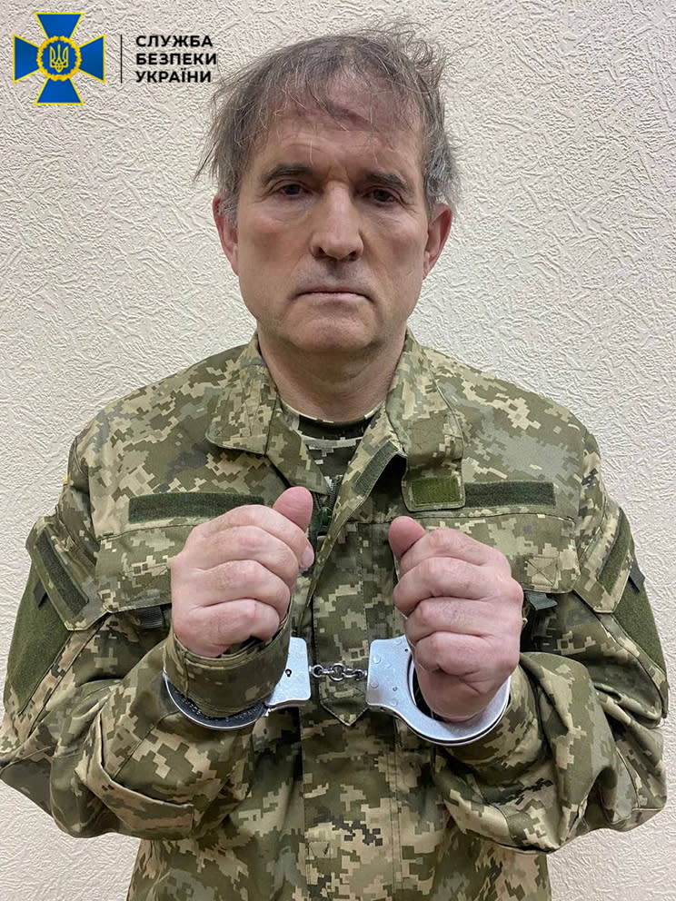 Pro-Russian Ukrainian politician Viktor Medvedchuk is seen in handcuffs while being detained by security forces in unknown location in Ukraine, in this handout picture released April 12, 2022. Press service of State Security Service of Ukraine/Handout via REUTERS ATTENTION EDITORS - THIS IMAGE HAS BEEN SUPPLIED BY A THIRD PARTY. PICTURE WATERMARKED AT SOURCE.